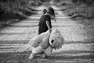 Child with Teddy-bear, sad, walking alone.