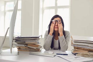 A photo of someone dealing with the stress, pain, and dysfunction inherent in many of today’s modern workplaces.