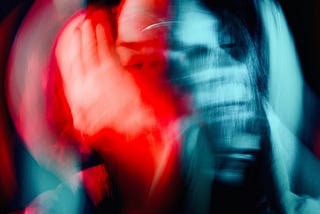 A blurred, abstract portrait of a person in motion, with overlapping red and blue lighting effects.