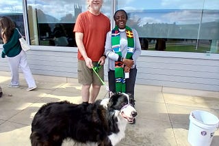 Williams College. James and his english shepherd dog being blessed by the chaplain in front of Pareski Hall. 2024. St. Francis Day