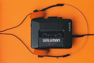 A Sony Walkman sits on an orange background