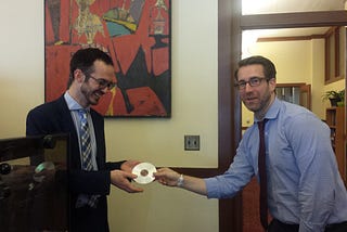 Picture showing two government employees using a CD to exchange data.