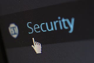 A mouse hovering over the word security on a computer screen to represent AllForCrypto offering security and scam prevention.