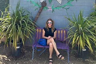 Amy Cuevas Schroeder, founder of The Midst, sitting on a bench