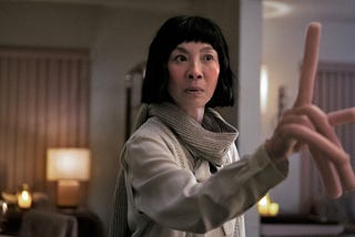 Michelle Yeoh holding up a hot-dog sized finger