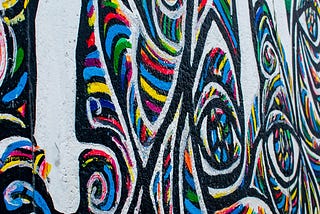 Graffiti showing an abstract image of bands of colour mixing and crossing paths