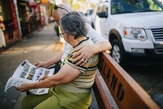 Couple Reading Newspaper on a bench