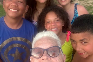 Selfie of author with five grandkids at a cabin on the lake.