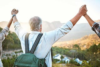 Elder celebrating a hike with friends outdoors.