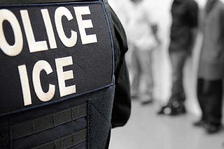 Black and white image of the back of a uniform with “Police, ICE.”