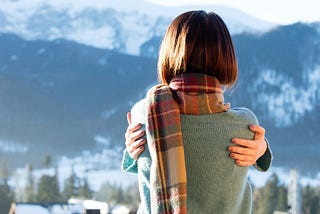 Portrait of a young redhead woman in winter mountains.