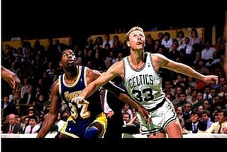 Magic Johnson of the Los Angeles Lakers playing against Larry Bird of the Boston Celtics during the 1987 NBA Finals. Bird attempts to box out Johnson for a rebound.