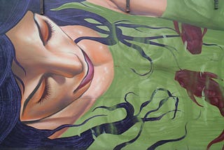 Street art of a dark-haired woman sleeping