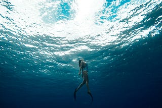 person swimming in the depths coming to the surface for air