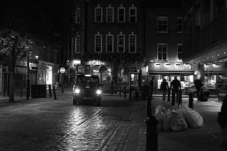 A London black taxi at night on a quiet cobbled street