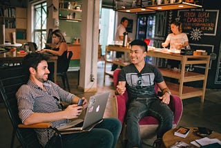 Men having a conversation while sitting in chairs.
