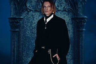 Jamie Campbell Bower over a blue Gothic background