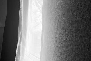 Black and White: light getting in through a slightly open curtain.