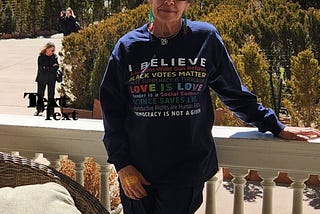 Author standing with shirt on that says: I Believe that no person is illegal