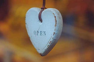 wooden heart hanging from strap with OPEN written on it