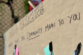 Sharpie writing on butcher block paper that reads “School Renaming” What does this community mean to you?” and some un filled out sticky notes.