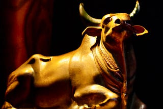 a brass bull in darkness