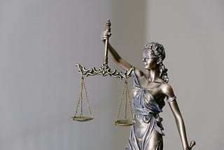 sculpture of Lady Justice blindfolded and holding balance scales