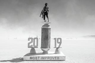 Samuel stands atop a giant Most Improved 2019 trophy