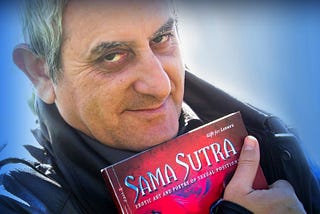 Image of Samarel the erotic artist of ‘Samarel Eros’, holding his sex positions art book ‘Sama Sutra’