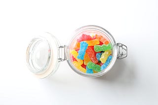 View from above an open mason jar full of sour candies.