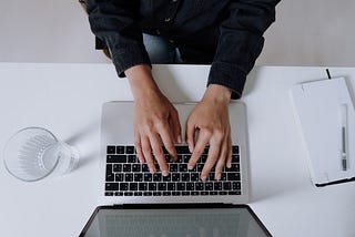 Person in black long sleeve shirt using MacBook Pro to blog