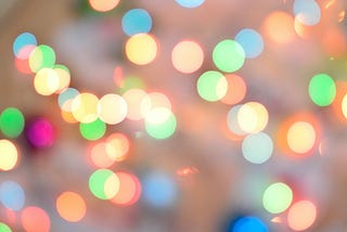 Light spots or flares on a blurred background, with pops of fuchsia, blue, green, and yellow