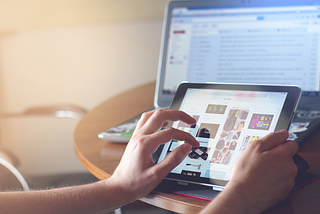 A human hand scrolling through what seems to be a catalogue.