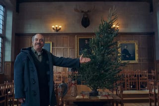 Paul Giamatti stands next to a Christmas Tree in The Holdovers