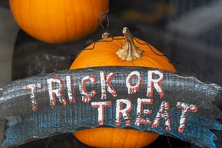Pumpkin with sign reading “Trick or Treat.”
