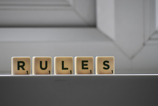 A group of Scrabble tiles that spell out “RULES”.