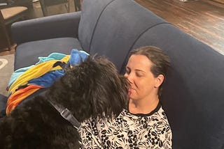 A picture of my dog Hermione licking my face while I try to meditate on the couch.