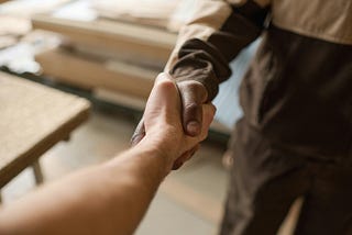 Close-up of two people from different ethnic backgrounds shaking hands.