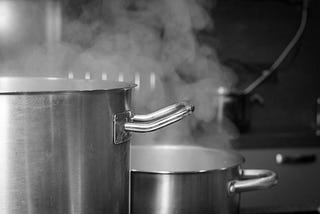 Steaming pots in a black and white.