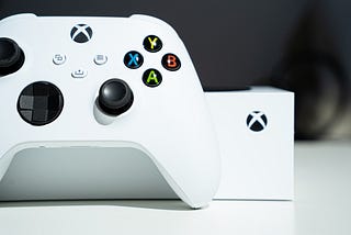 A white Series controller in front of an Xbox Series S