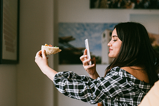girl taking photo of pizza from her iphone