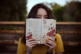 woman reading the Handmaid’s Tale book