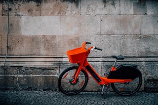 Orange e-bike parked on a street.