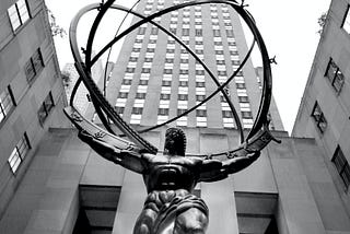 A bronze statue of Atlas holding the world — placed somewhere in NewYork — amongst skyscrapers