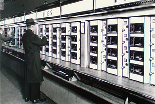 man standing at Automat food vending wall