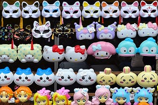 A wall of anime dolls — hello kitty and others, ad some cat masks