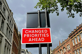 A street sign that says “changed priorities ahead.”