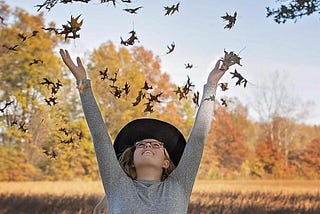 young girl throwing leaves in the air