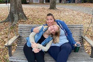 Photo of the author and her daughter sitting together on a bench outside.