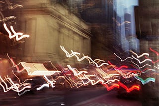 A blurry artistic photo looking northward on third avenue in new york city. The lights from the cars are squiggly and moving as the image was taken at night.